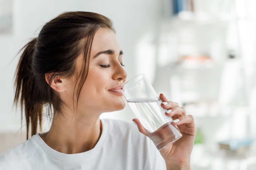 Young woman drinking water to hydrate