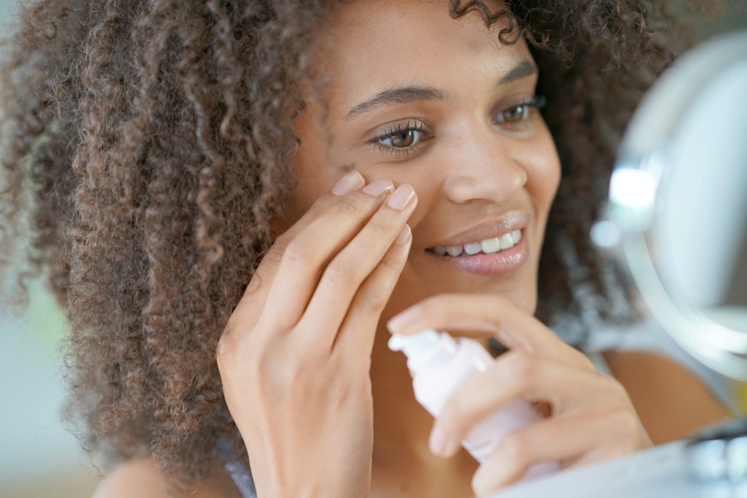 Young woman applying Eminence skin care